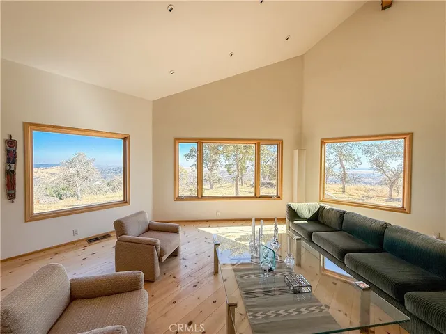 a dining room with wooden floor a chandelier a wooden table and chairs