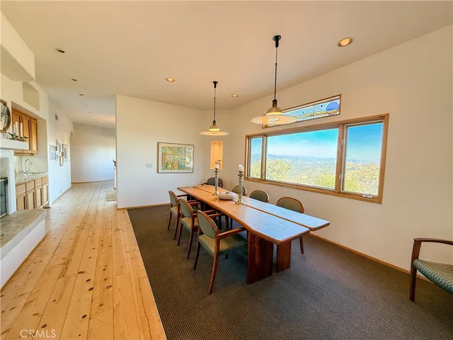 a view of a hallway with wooden floor and a bathroom