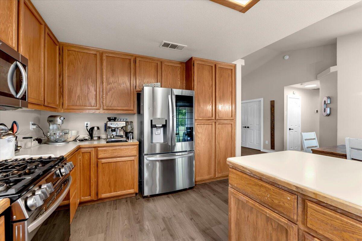 1675 Hominy Way Redding, CA 96003 - Photo 14 of 38 a kitchen with stainless steel appliances a refrigerator a sink and wooden cabinets