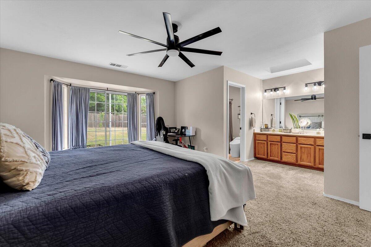 1675 Hominy Way Redding, CA 96003 - Photo 16 of 38 a bed room with a bed and a ceiling fan
