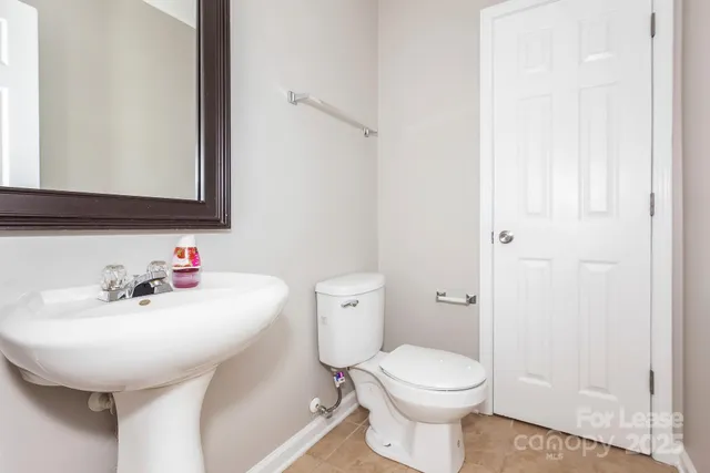 a bathroom with a sink a toilet and mirror