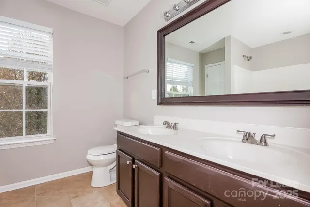 a bathroom with a sink a toilet and a window