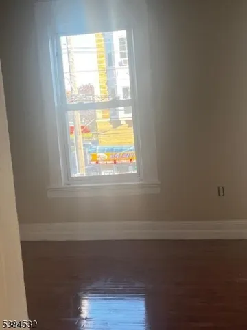 a view of a small space with wooden floor and a window