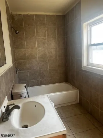 a bathroom with a sink a bathtub and window