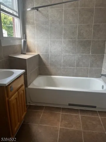 a bathroom with a granite countertop sink a toilet and bathtub