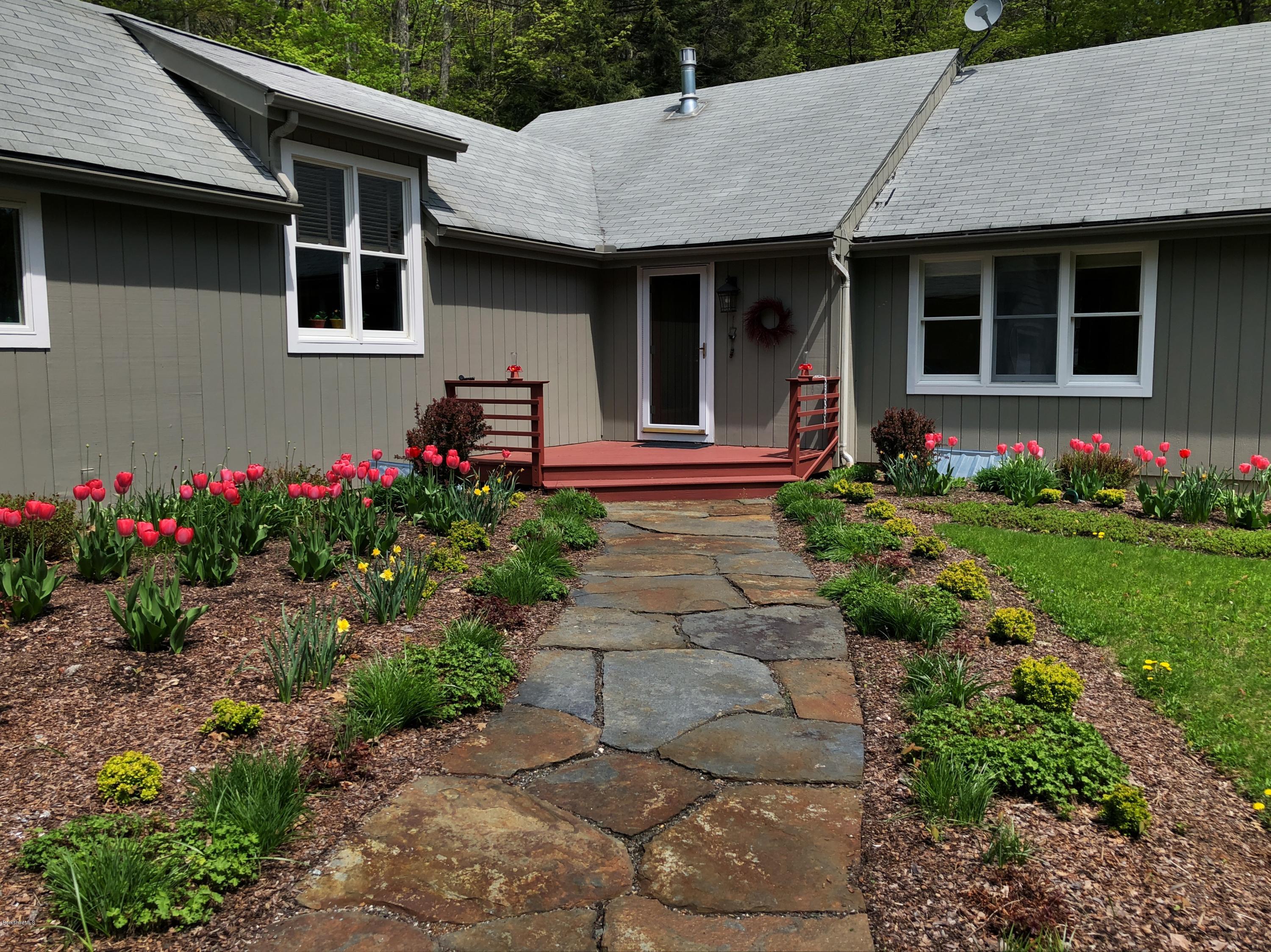 131 Tyringham Road Otis, MA 01253 - Photo 4 of 46 a front view of a house with a garden