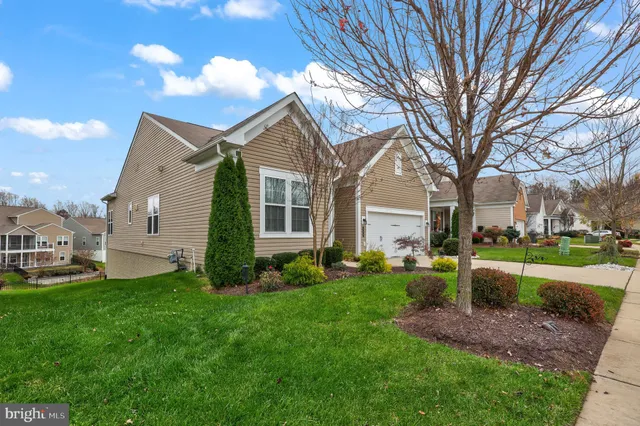 a front view of a house with a yard and trees