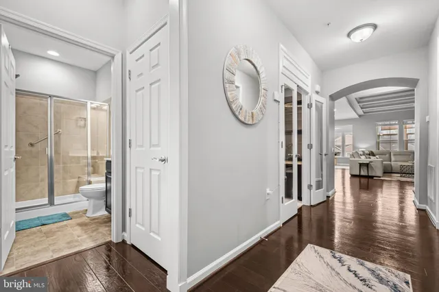 a view of a hallway with bathroom and wooden floor