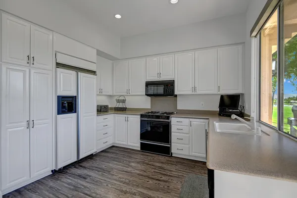 a kitchen with stainless steel appliances granite countertop a stove a sink and a refrigerator