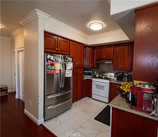 a kitchen with stainless steel appliances kitchen island granite countertop a refrigerator stove and sink