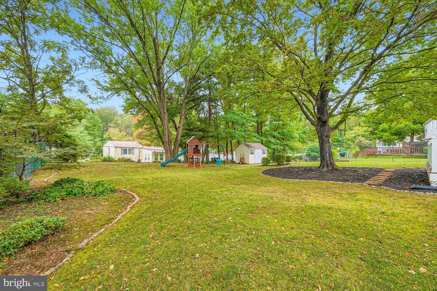 15604 Wembrough Street Silver Spring, MD 20905 - Photo 29 of 33 Spacious yard with lush greenery and playset.