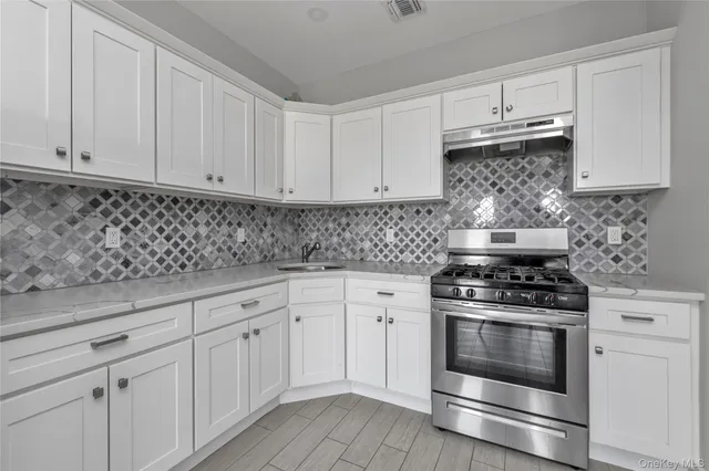 a kitchen with white cabinets and appliances