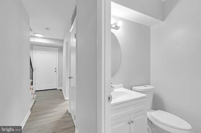 a bathroom with a granite countertop toilet and sink