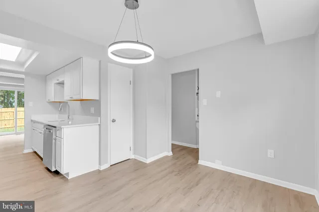 a view of a kitchen with a sink and dishwasher a refrigerator with wooden floor