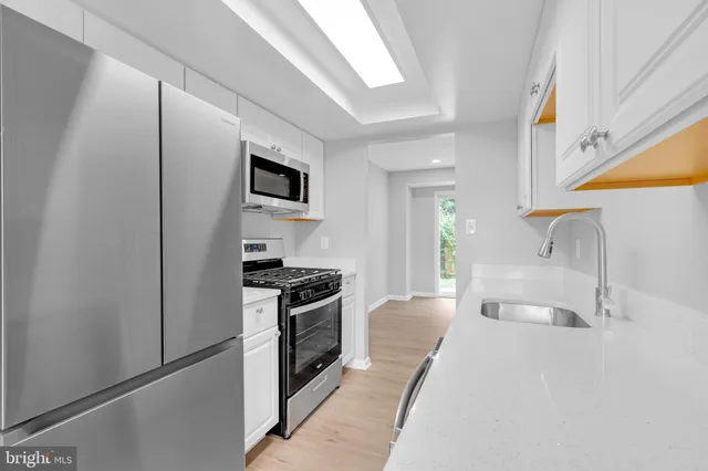 a kitchen with stainless steel appliances granite countertop a sink and a stove