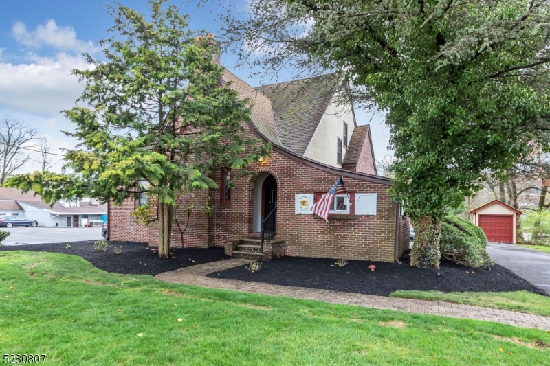 a view of backyard with a barn and large trees
