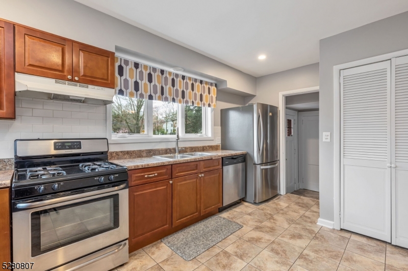 153 Stirling Road Watchung, NJ 07069 - Photo 18 of 31 a kitchen with stainless steel appliances granite countertop a stove a sink and a refrigerator