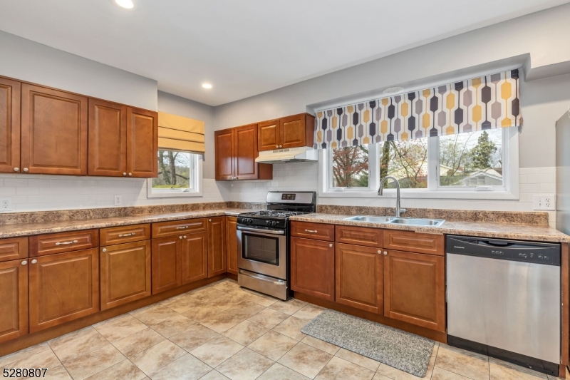 153 Stirling Road Watchung, NJ 07069 - Photo 20 of 31 a kitchen with stainless steel appliances granite countertop a stove sink and cabinets