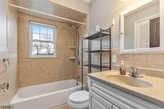 a bathroom with a granite countertop sink toilet and bathtub