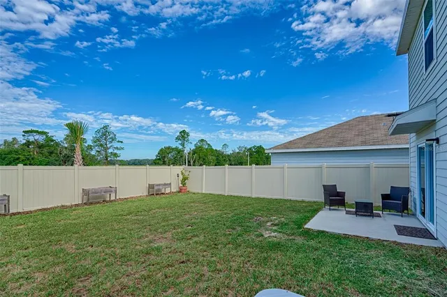 a view of a backyard with plants and large tree