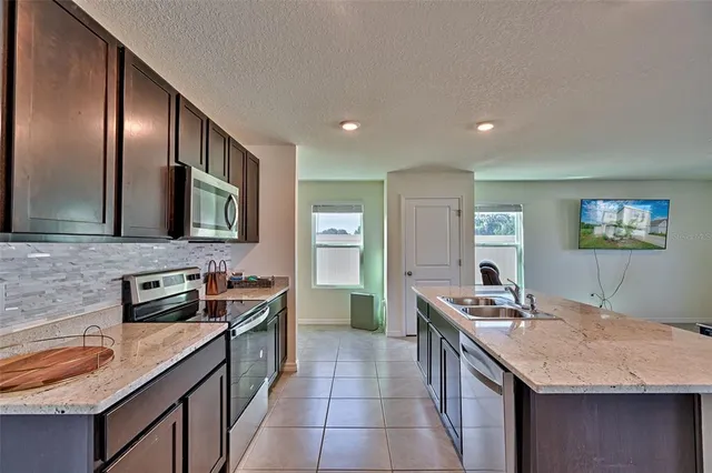 a kitchen with stainless steel appliances granite countertop a refrigerator and a stove