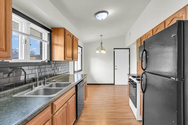 a kitchen with stainless steel appliances granite countertop a sink refrigerator and cabinets