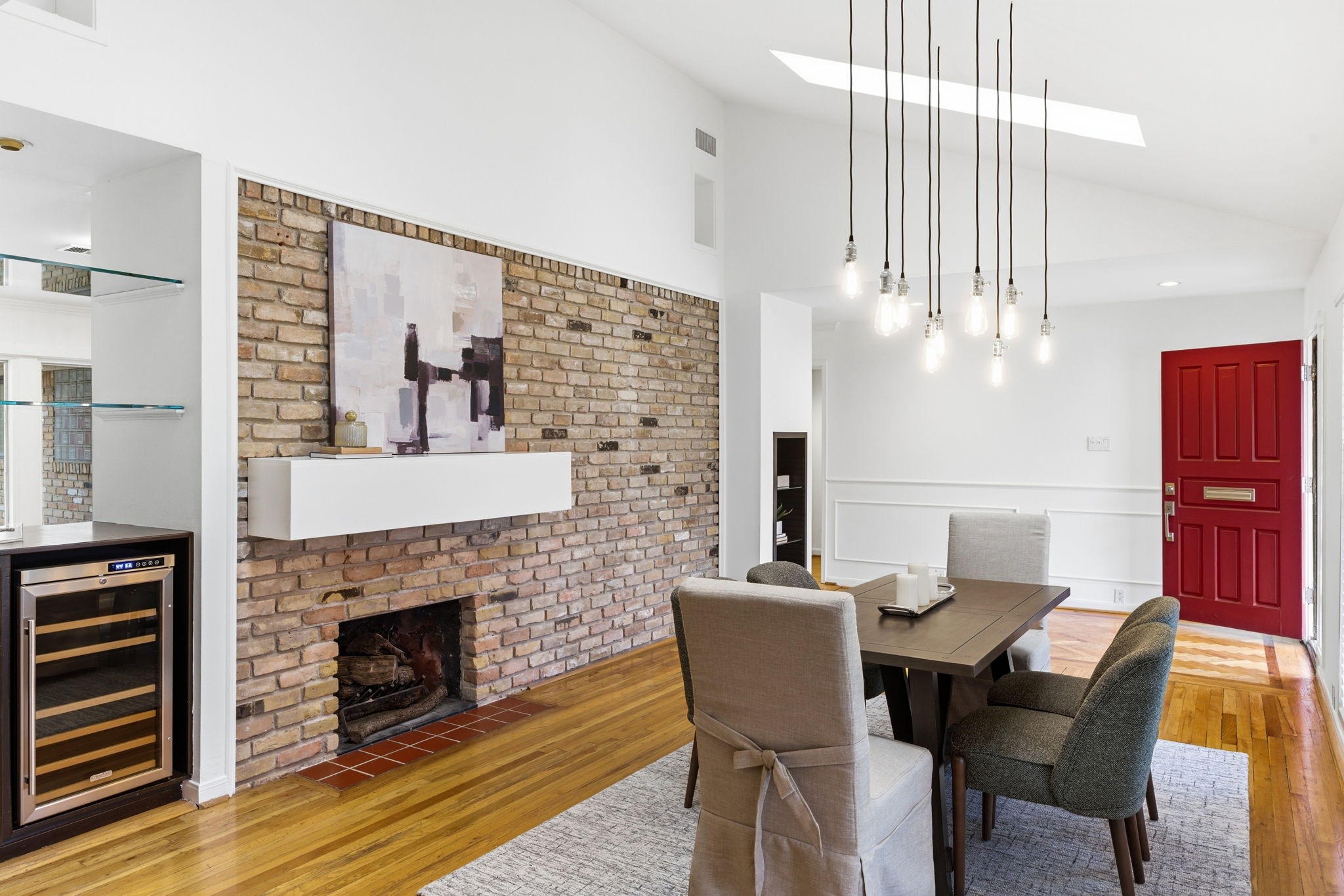 The brick fireplace serves as a warm focal point, complemented by newly painted walls and trim that give the space a refined finish. Just beyond, the updated wet bar and clean architectural lines continue the home’s cohesive, move in ready feel.