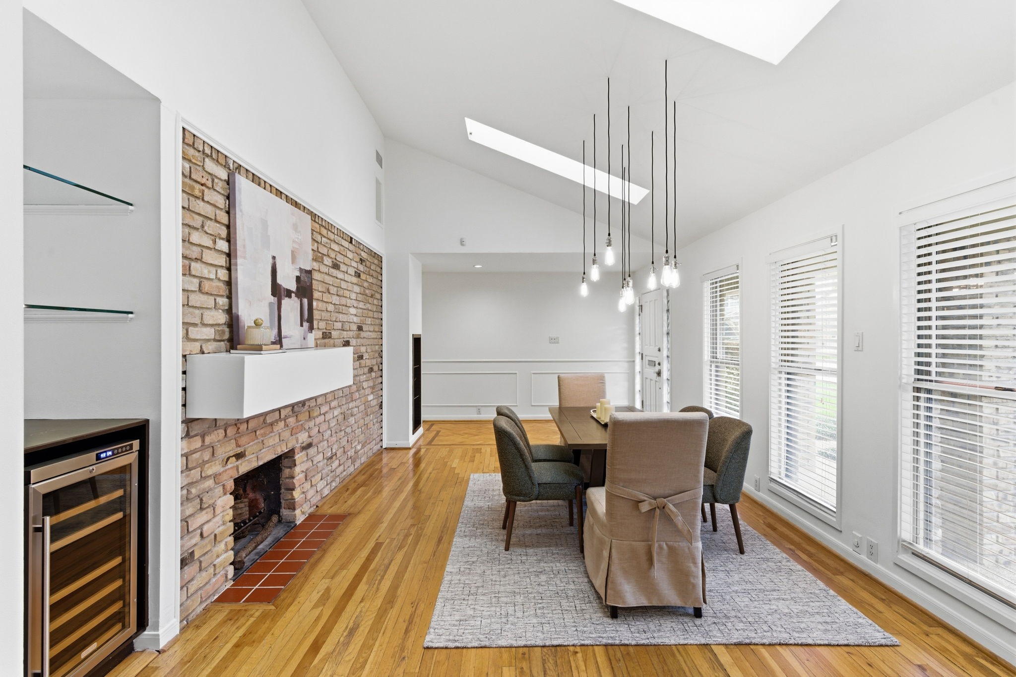 531 Azaleadell Drive Houston, TX 77018 - Photo 12 of 37 The dining area feels open and elevated beneath vaulted ceilings and skylights that draw in beautiful natural light. Freshly painted walls and trim brighten the space, while the exposed brick fireplace adds warmth and timeless character.