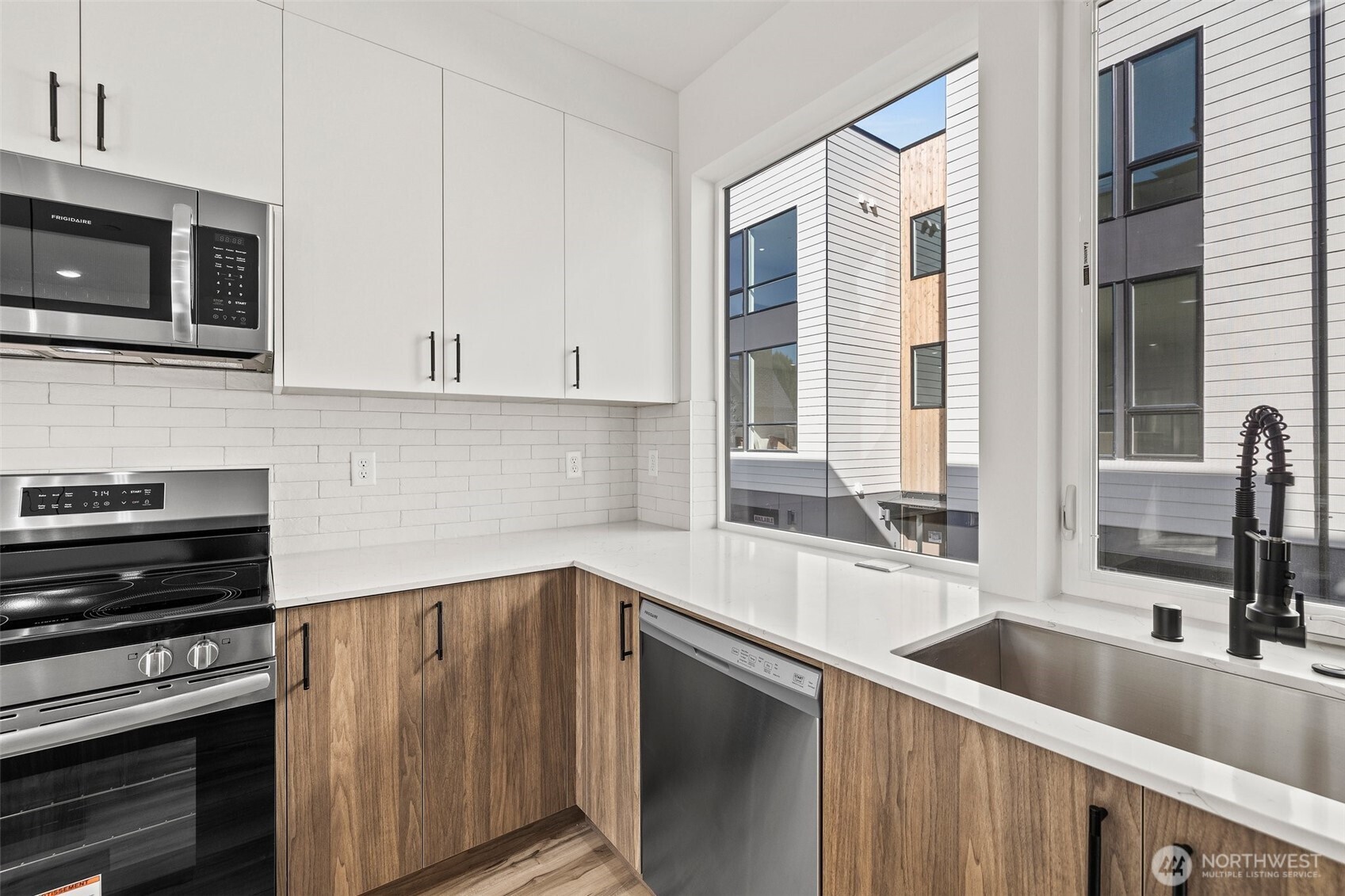 8322 16th Avenue Northwest, Unit D Seattle, WA 98117 - Photo 12 of 24 a kitchen with stainless steel appliances a sink a stove and cabinets