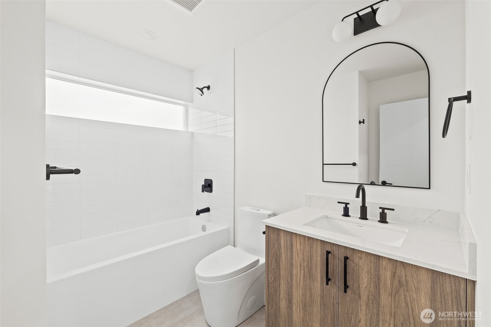 8322 16th Avenue Northwest, Unit D Seattle, WA 98117 - Photo 22 of 24 a bathroom with a bathtub shower sink mirror and toilet