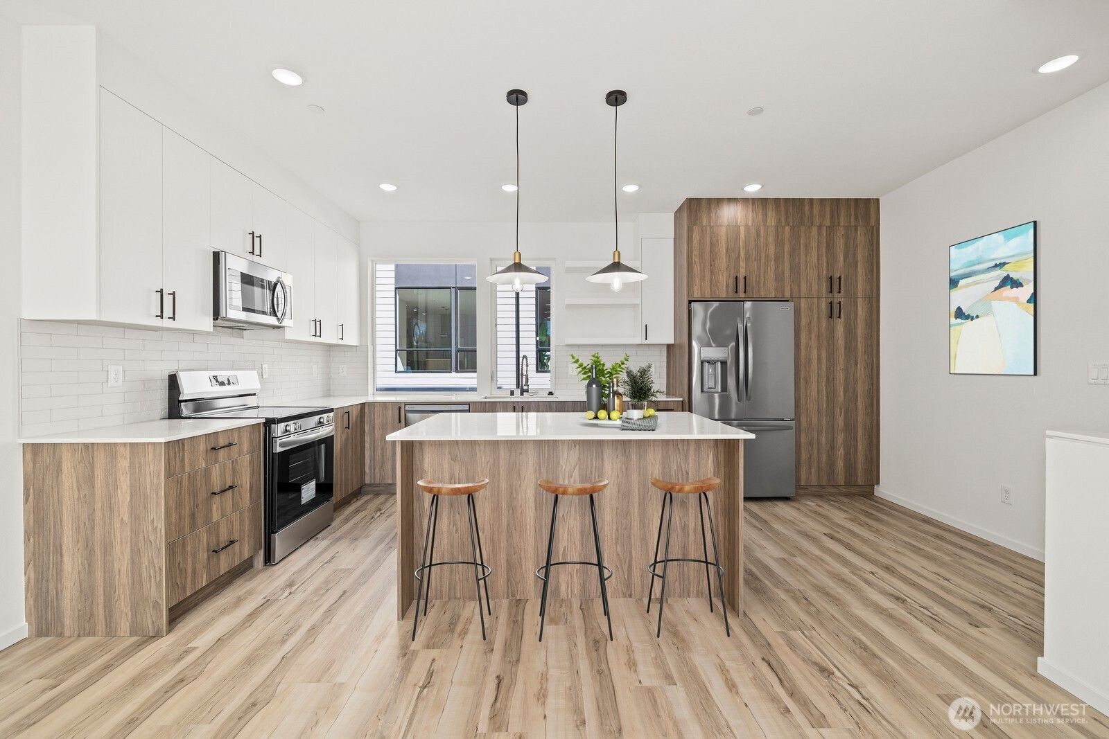 8322 16th Avenue Northwest, Unit D Seattle, WA 98117 - Photo 5 of 24 a kitchen with stainless steel appliances granite countertop a refrigerator a sink dishwasher a stove and white countertops with wooden floor