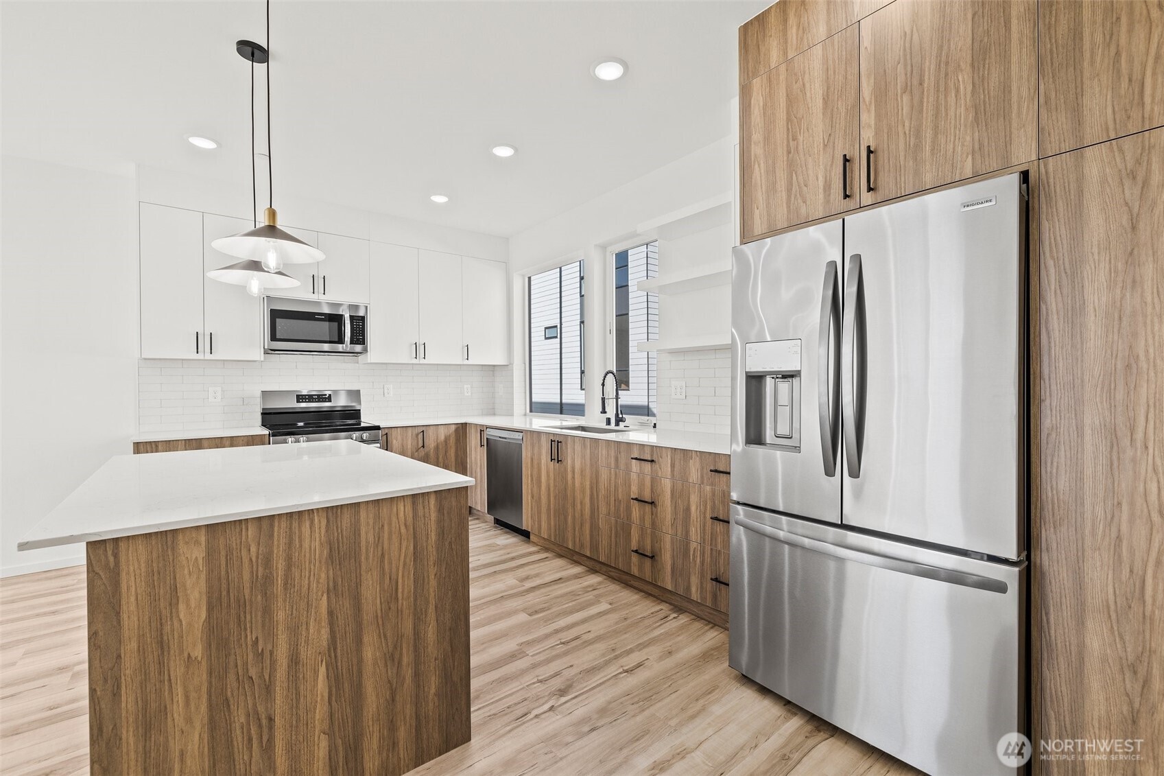8322 16th Avenue Northwest, Unit D Seattle, WA 98117 - Photo 6 of 24 a kitchen with kitchen island white cabinets and stainless steel appliances