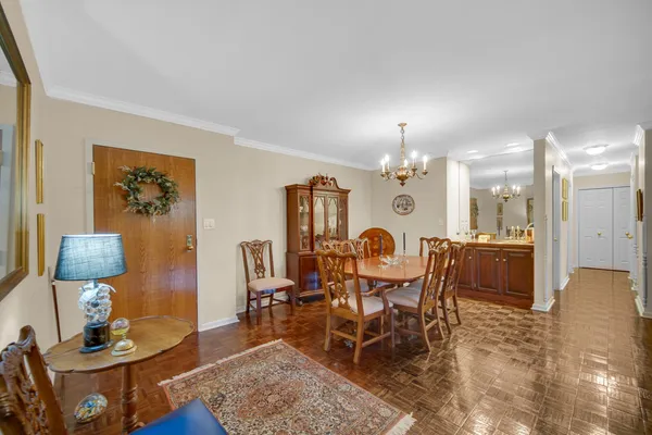 a dining room with wooden floor a glass table and chairs