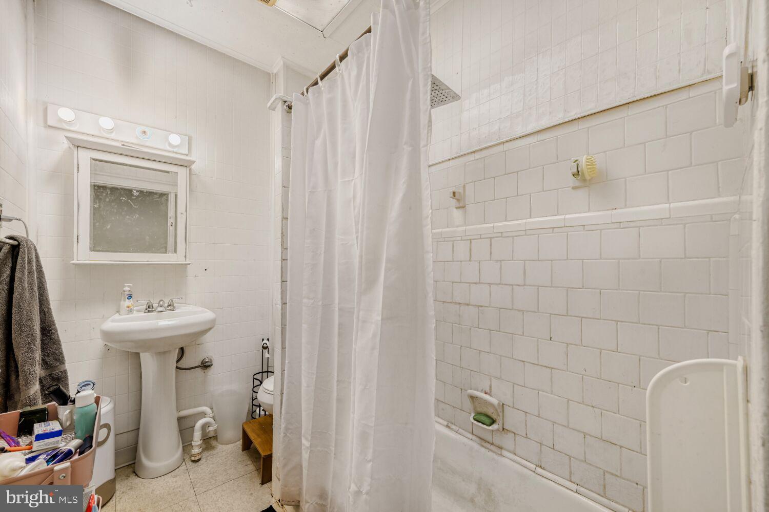 3703 Belair Road Baltimore, MD 21213 - Photo 11 of 22 a bathroom with a sink a toilet and shower