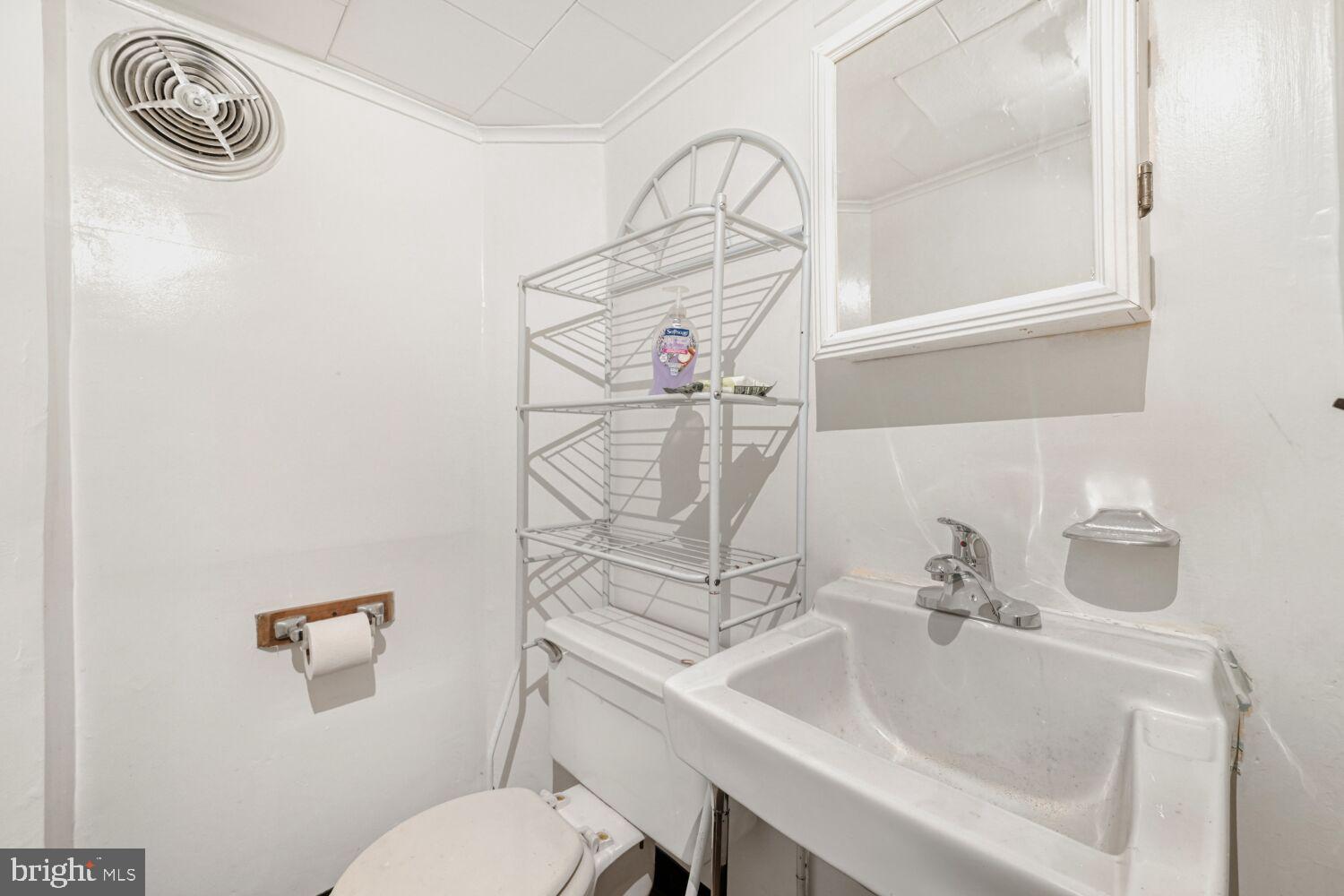 3703 Belair Road Baltimore, MD 21213 - Photo 12 of 22 a bathroom with a sink a toilet and mirror