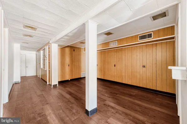 a view of empty room with wooden floor