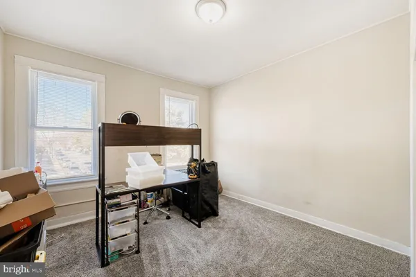 a bedroom with a bed a couch and a potted plant