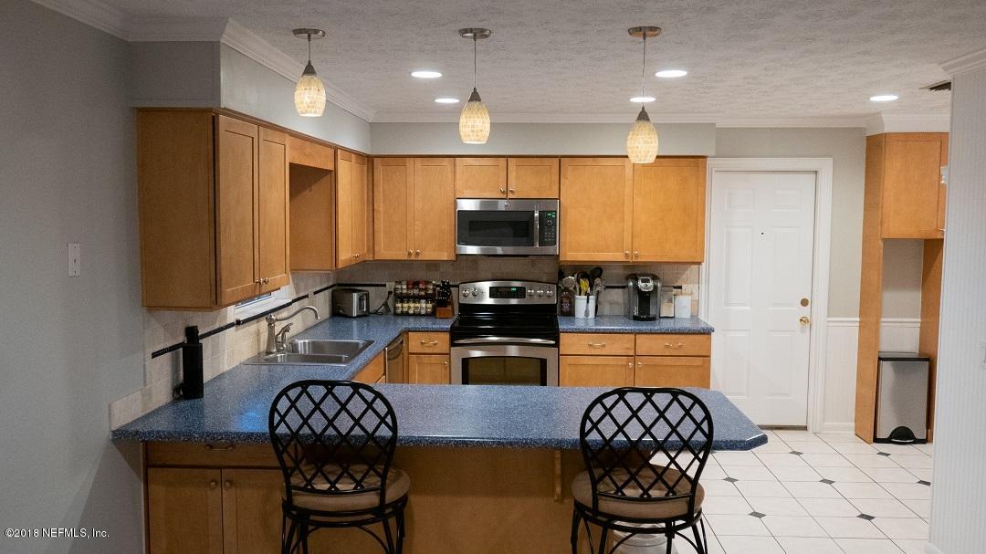 8918 San Rae Road Jacksonville, FL 32257 - Photo 16 of 33 a kitchen with stainless steel appliances granite countertop a refrigerator a sink a stove a dining table and chairs with wooden floor