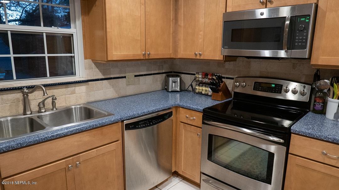 8918 San Rae Road Jacksonville, FL 32257 - Photo 19 of 33 a kitchen with stainless steel appliances a stove a microwave and sink