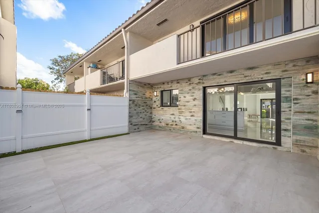 a room with lots of potted plants and glass windows