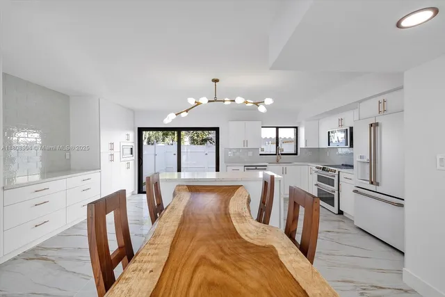 a view of a kitchen with dining table and chairs