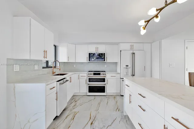 a kitchen with granite countertop white cabinets and stainless steel appliances