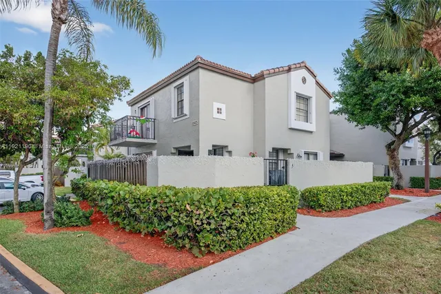 a front view of a house with a yard and potted plants