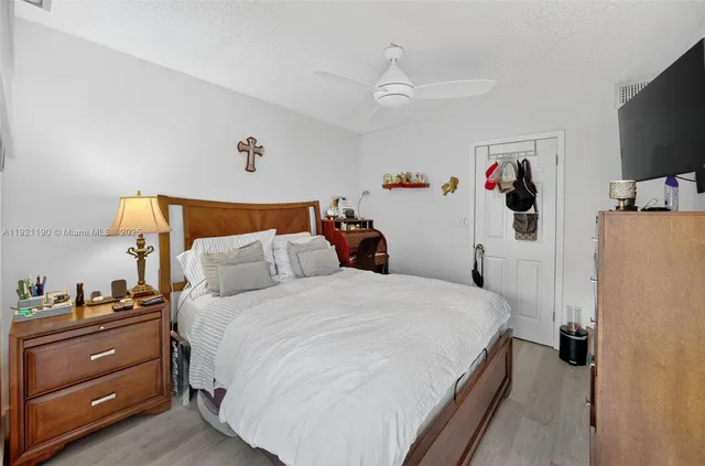 a bedroom with a bed and a flat tv screen on the dresser
