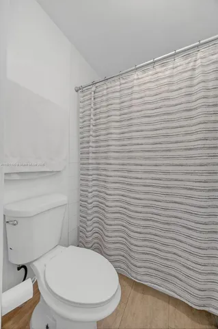 a bathroom with a toilet and a shower curtain