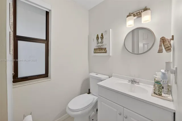 a bathroom with a toilet a sink and mirror