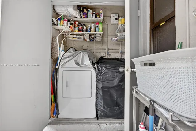 a utility room with dryer washer and a view of living room