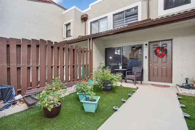a front view of a house with a yard garden and outdoor seating