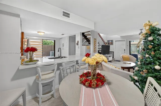 a dining room filled chandelier and kitchen view
