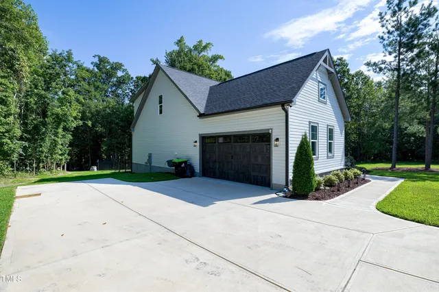 an aerial view of residential houses with outdoor space and trees